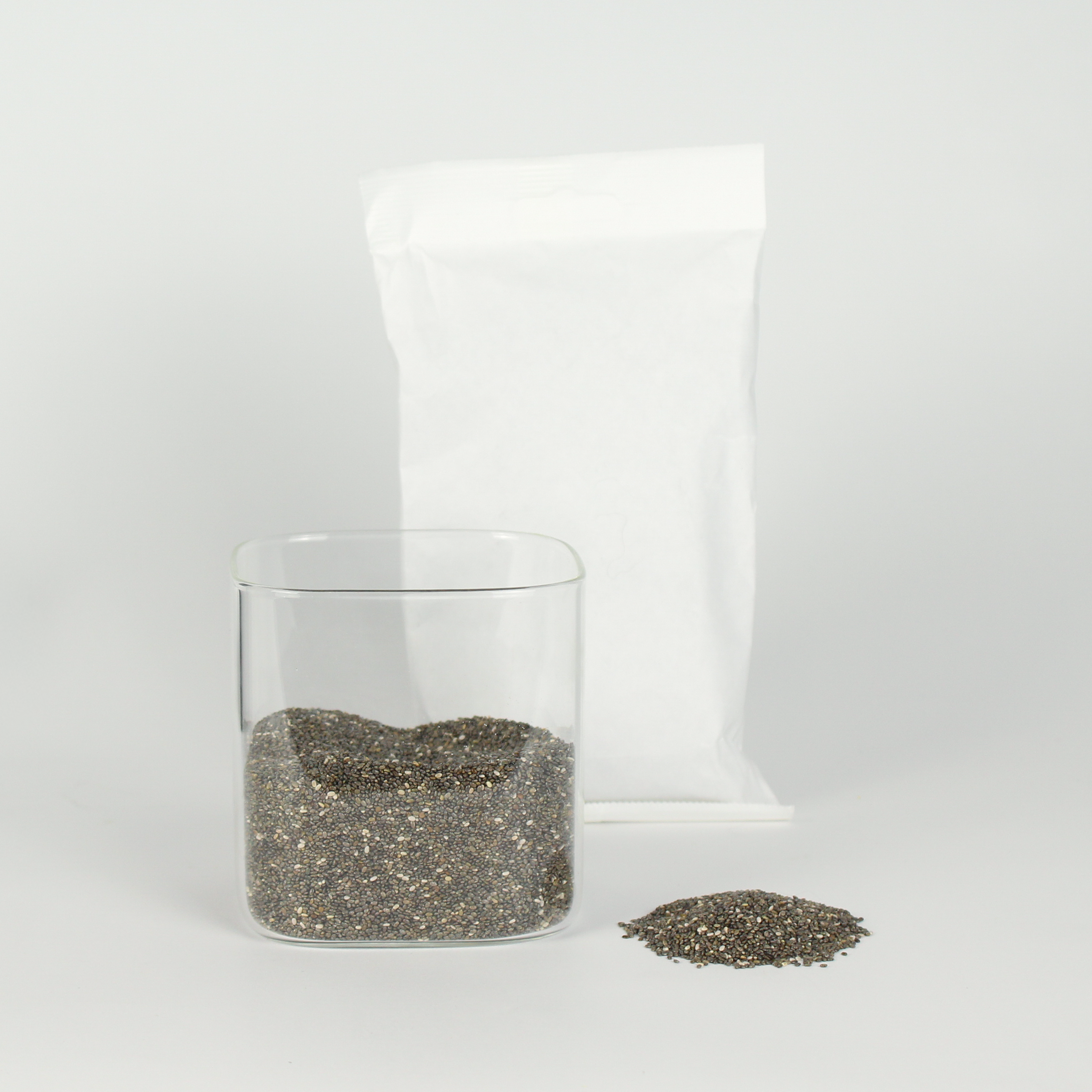 Clear glass container with chia seeds on a white background