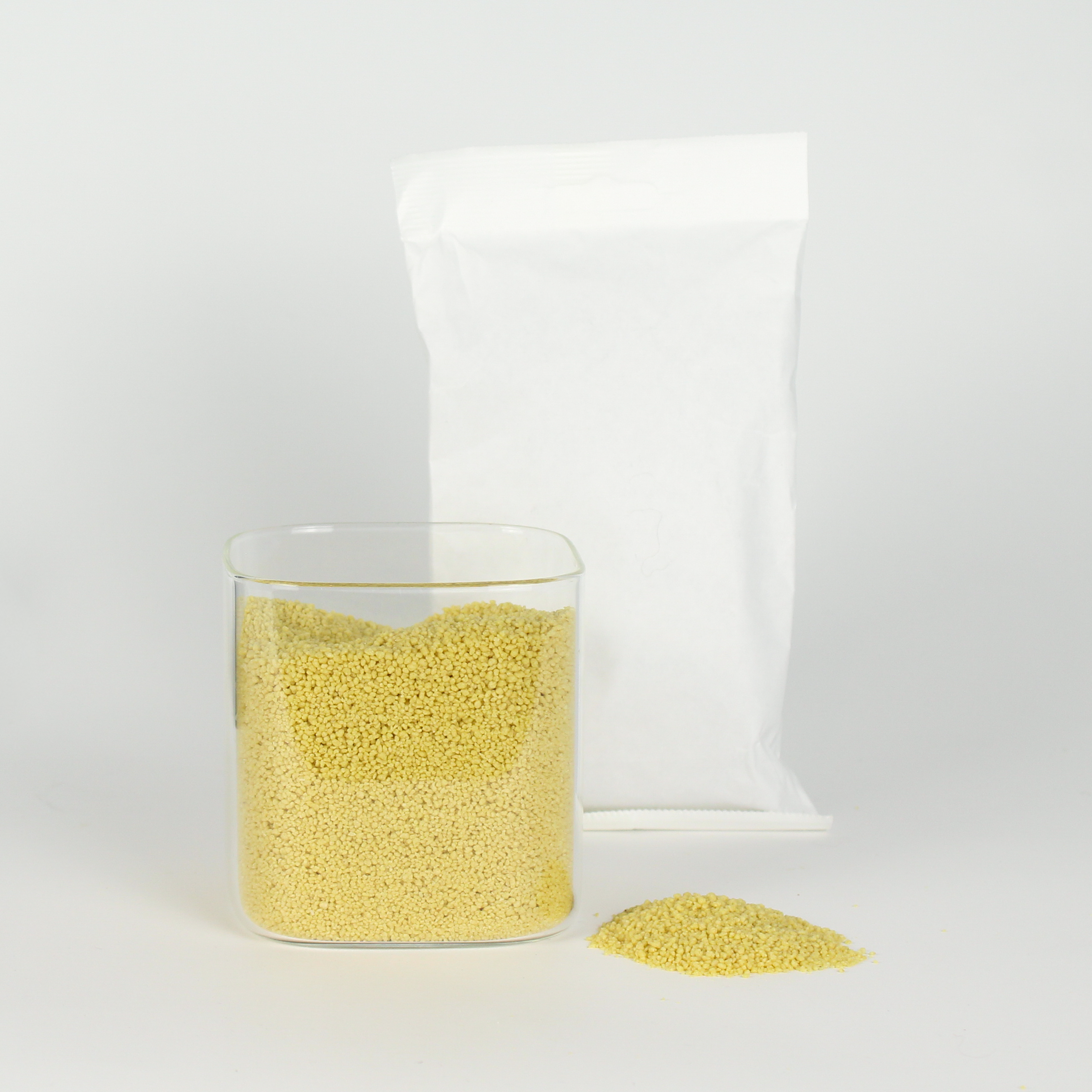 Clear container with couscous and a white bag on a light gray background