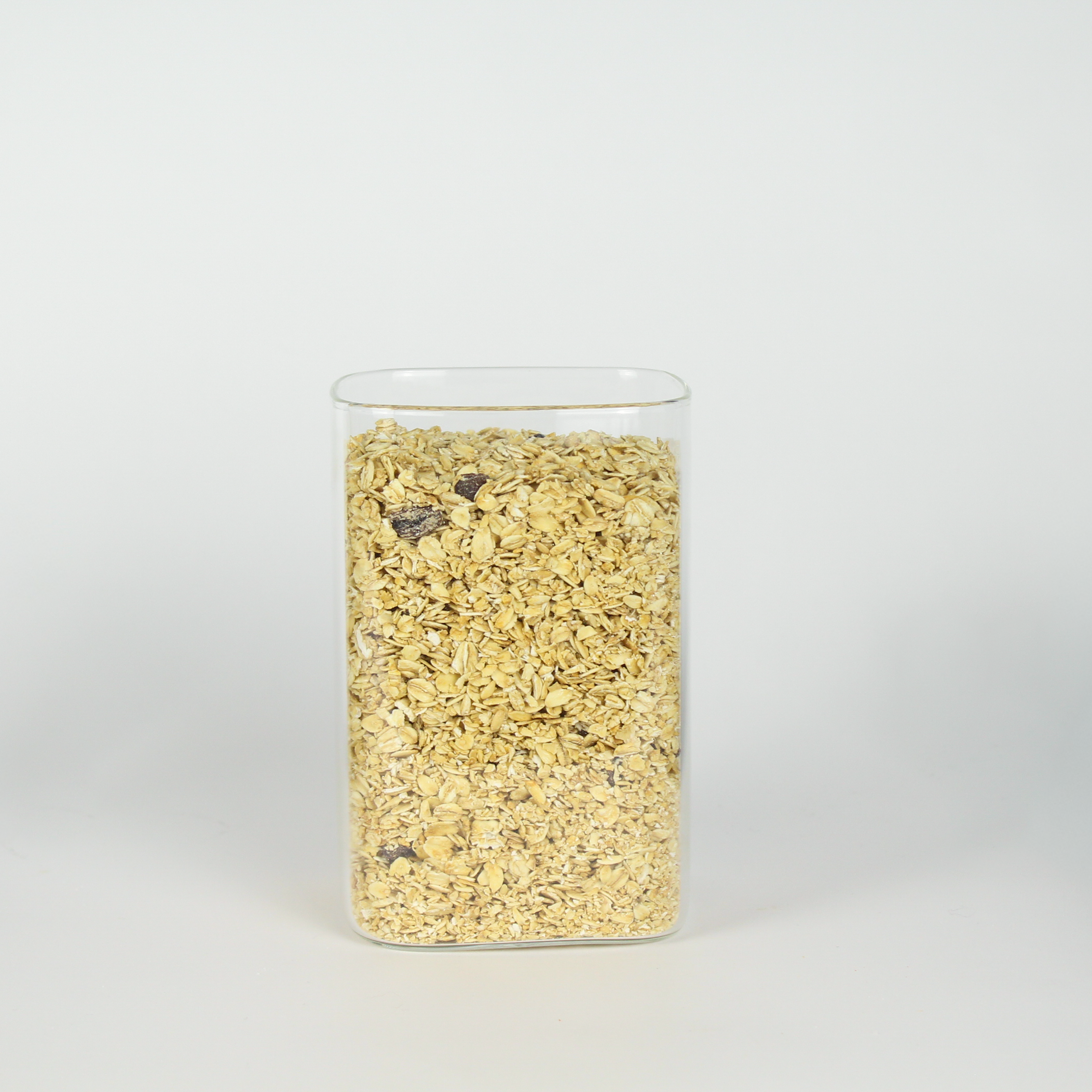 Glass container filled with a granular substance on a white background